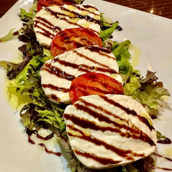 Nico's Caprese salad with mozzarella, tomatoes, lettuce, olive oil, and balsamic glaze.